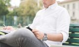 graphicstock-young-contemporary-businessman-remote-working-sitting-on-a-bench-outdoor-in-a-city-wiritng-on-her-agenda-organizing-small-business-remote-working_rpxybmyYyZ