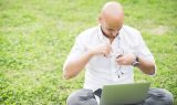 graphicstock-young-contemporary-businessman-remote-working-sitting-outdoor-in-a-city-park-using-computer-and-earphones-portability-small-business-business-call-concept_rTAZ7kt1-